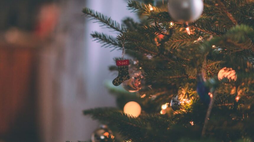 Egy száradó karácsonyfa díszítése, rajta egy kis zokni és fények.