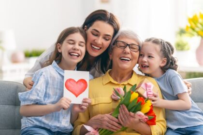 Egy boldog család három generációja, akik Anyák napját ünneplik, virágokkal és szeretetteljes ajándékokkal.