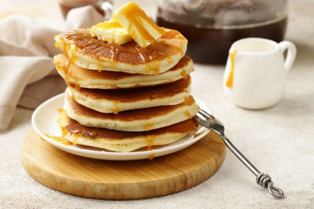 Egy tál amerikai palacsinta, vajjal és mézzel megöntözve, fából készült tányéron.