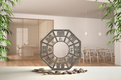 Egy feng shui szimbólum, amely harmonikus energiát sugároz, zöld növényekkel és sima kövekkel körülvéve.