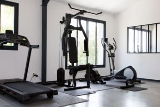 Egy modern otthoni edzőterem, ahol futópad, kondigép és elliptikus tréner található.