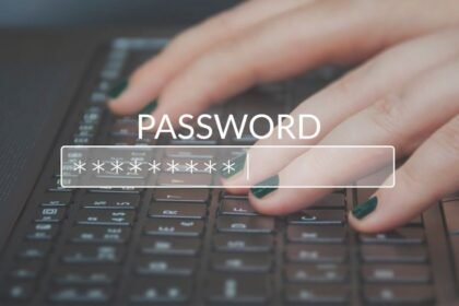 Egy kéz gépel egy jelszót egy laptop billentyűzetén, a képernyőn a 'PASSWORD' felirat látható.