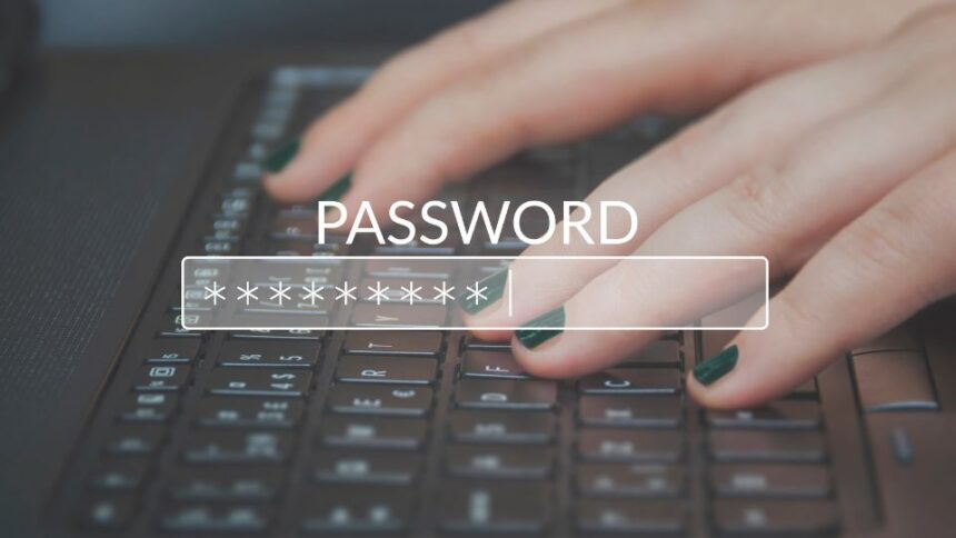 Egy kéz gépel egy jelszót egy laptop billentyűzetén, a képernyőn a 'PASSWORD' felirat látható.