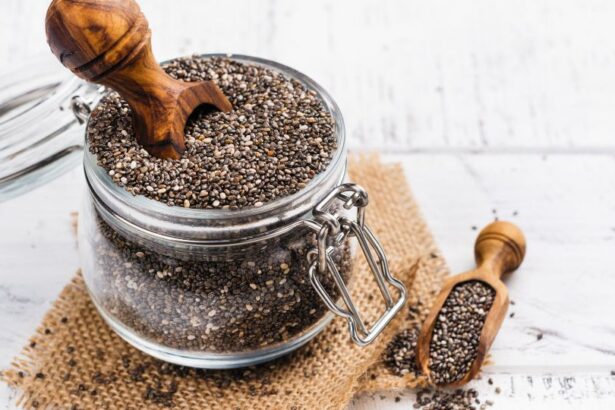 Egy üvegben chia magok láthatók, mellette egy kis fa kanál, amelyből néhány mag kiömlött.