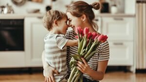 womensway 130 Egy édesanya és kisfia ölelkezik, miközben tulipánokat tart a kezében, a konyhában.