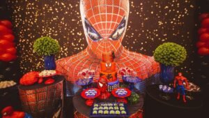 Egy Spider-Man témájú születésnapi buli dekorációja, ahol sütemények és figurák találhatók.
