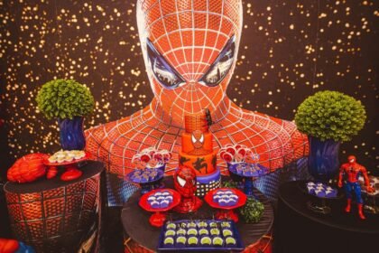 Egy Spider-Man témájú születésnapi buli dekorációja, ahol sütemények és figurák találhatók.
