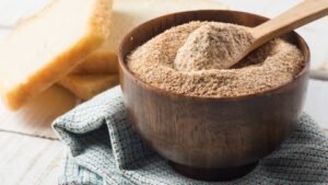 Pirított zsemlemorzsa egy fából készült tálban, mellette friss kenyérszeletek.