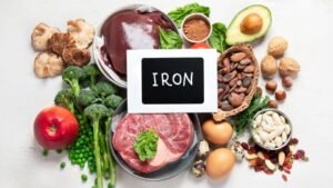 Vasban gazdag élelmiszerek, mint a hús, zöldségek, tojás és diófélék egy asztalon.