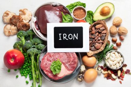 Vasban gazdag élelmiszerek, mint a hús, zöldségek, tojás és diófélék egy asztalon.