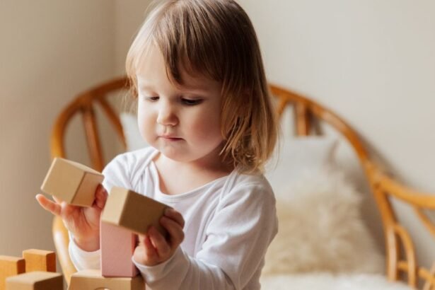 Egy hároméves kislány építőblokkokkal játszik, figyelmesen építkezik.