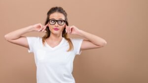 womensway 143 Egy fiatal nő, aki a fülét fogja, jelezve a füldugulás érzését nátha miatt.