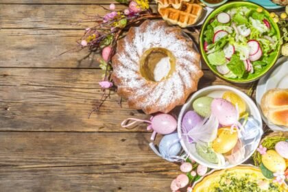 Húsvéti asztal gazdag ételekkel, színes tojásokkal és virágokkal díszítve.