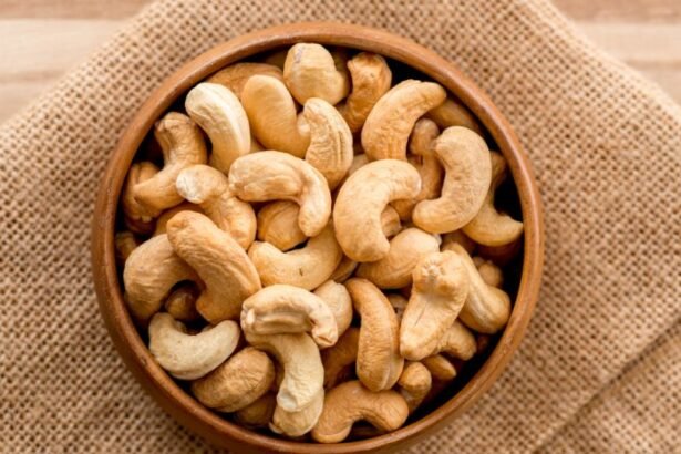 Egy fából készült tálban frissen pörkölt kesudiók láthatók, amelyek ízletes és tápláló nassolnivalók.