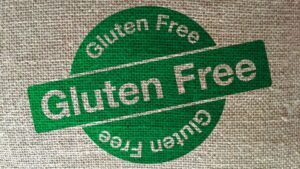 Zöld színű gluténmentes jelzés egy textil háttéren, amely a bőrápolás biztonságát hangsúlyozza.