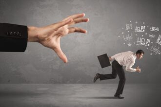 Egy férfi pánikban fut, míg egy hatalmas kéz próbálja elérni őt, a háttérben'Help!' feliratokkal.