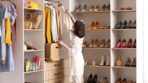 Egy nő a kapszula ruhatárából válogat, színes ruhák és cipők között.