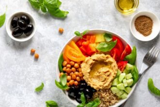 Színes mediterrán saláta hummusszal, zöldségekkel és olívabogyóval.