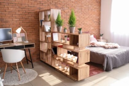 Modern lakásdekoráció, fa polcokkal, növényekkel és világítással, harmonikus otthoni környezet.