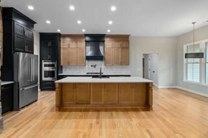 Modern konyha világítással, amely hangsúlyozza a tér letisztult vonalait és meleg színeit.