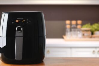 Egy modern, fekete Air Fryer konyhai pulton, digitális kijelzővel és gombokkal.