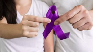 womensway 133 Egy nő és egy férfi közösen tartanak egy lila szalagot, amely a nők elleni erőszak ellenes küzdelem szimbóluma.