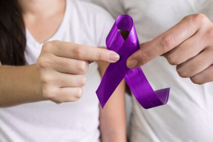 A nők elleni erőszak felszámolásának világnapja: Küzdelem egy igazságosabb világért 2 Egy nő és egy férfi közösen tartanak egy lila szalagot, amely a nők elleni erőszak ellenes küzdelem szimbóluma.