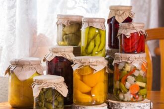 Több üveg befőtt, különböző zöldségekkel és gyümölcsökkel, természetes tartósítással.