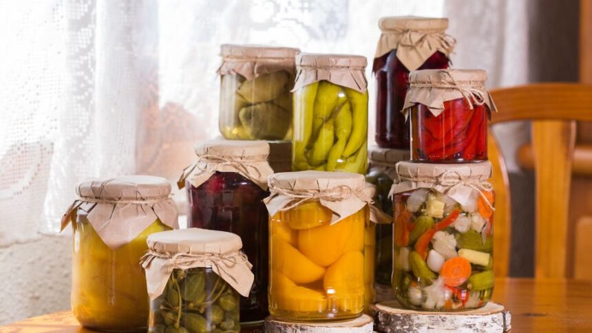 Több üveg befőtt, különböző zöldségekkel és gyümölcsökkel, természetes tartósítással.