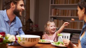 Egy új partner és egy gyermek közös étkezés közben, vidám pillanatokkal.