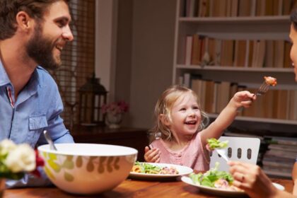 Egy új partner és egy gyermek közös étkezés közben, vidám pillanatokkal.