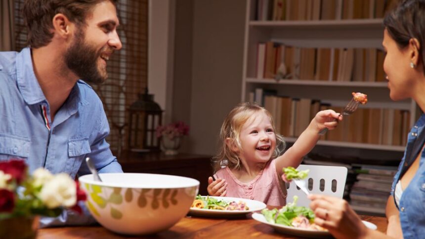 Egy új partner és egy gyermek közös étkezés közben, vidám pillanatokkal.