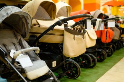 Különböző stílusú babakocsik sorakoznak egy boltban, különböző színekben és formákban.