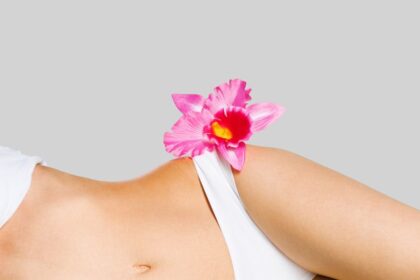 Egy női vállon egy szép virág, amely a szépségápolás és az intim gyantázás témájához kapcsolódik.