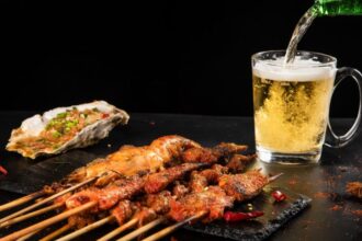 Grillezett húsnyársak és egy pohár sör, frissítő ízekkel a grillpartihoz.