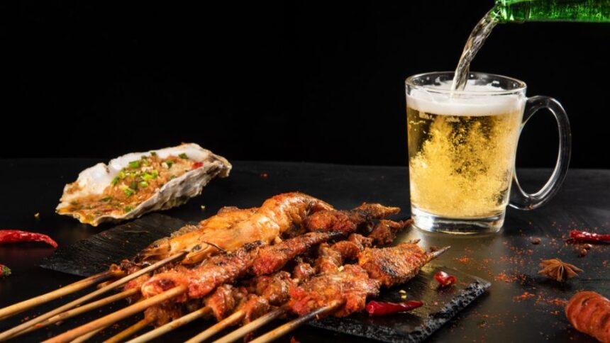 Grillezett húsnyársak és egy pohár sör, frissítő ízekkel a grillpartihoz.