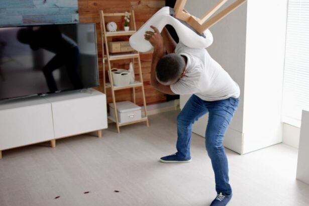 Egy férfi egy széket emel a levegőben, miközben csótányokat próbál eltávolítani a lakásban.