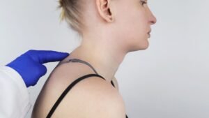 womensway 138 Egy nő profilból látható, amint orvosi vizsgálat során a háti gerincét ellenőrzik.