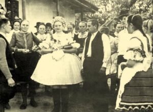 Hagyományos népviseletbe öltözött emberek gyűlnek össze Szent Mihály napján, ünnepi hangulatban.