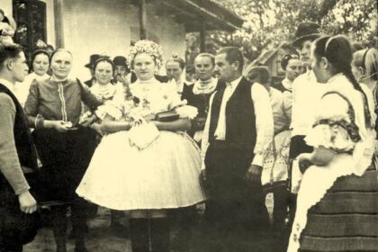 Hagyományos népviseletbe öltözött emberek gyűlnek össze Szent Mihály napján, ünnepi hangulatban.