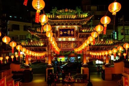 Éjszakai fényekben tündöklő kínai templom, piros lampionokkal díszítve, amely a kínai kultúra gazdagságát tükrözi.