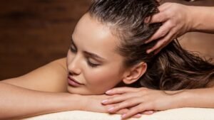 womensway 129 Egy nő élvezi a fejbőrmasszázst, miközben a haja nedvesen omlik le.