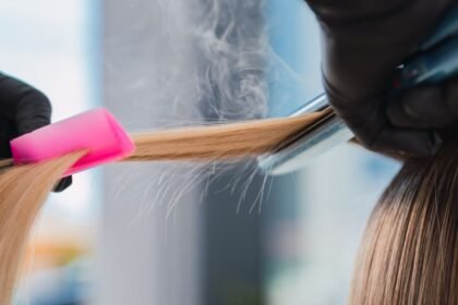 Keratinos hajegyenesítés folyamata, hajvasaló és fésű használatával.