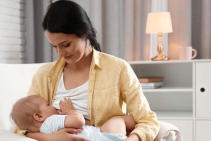 Egy édesanya szoptatja kisbabáját egy kényelmes kanapén.