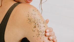 Egy nő vállán testradír látható, természetes összetevőkkel.