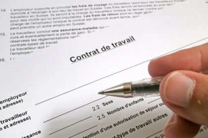 Egy kéz egy munkaszerződés felett, amely fontos részleteket tartalmaz.