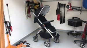 Babakocsi tárolása egy garázsban, eszközök mellett.