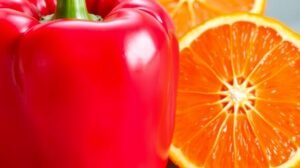 Egy piros paprika és narancs szeletek, C-vitamin források.