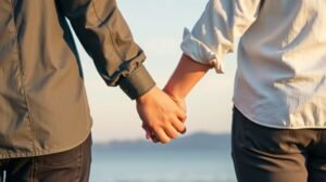 Pár kézen fogva áll a naplementében, újraépítve bizalmukat.