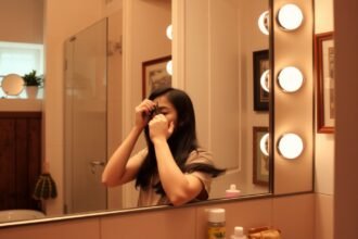 Hajvágás otthon, nő tükör előtt haját vágva